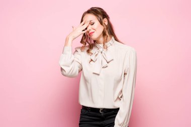 Pembe bir arka plan üzerinde ciddi hayal kırıklığına uğramış genç güzel iş kadını