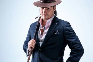 Genç portre studio gri arka plan üzerinde şapkalı adam.