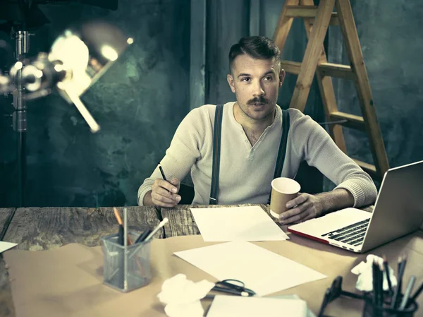 Retrato de um empresário barbudo que está trabalhando com seu caderno no estúdio loft . — Fotografia de Stock