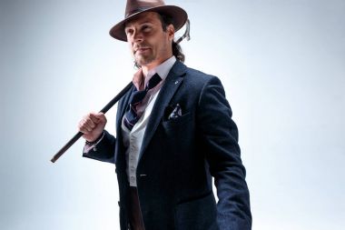 Baston tutan bir takim elbisesi ve olgun adam.