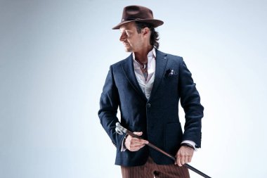 Baston tutan bir takim elbisesi ve olgun adam.