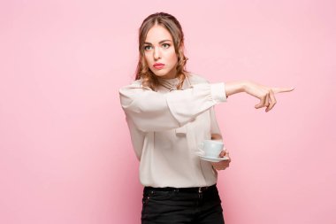 Pembe bir arka plan üzerinde ciddi hayal kırıklığına uğramış genç güzel iş kadını