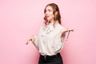 Pembe bir arka plan üzerinde ciddi hayal kırıklığına uğramış genç güzel iş kadını