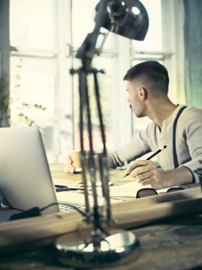 Ofisteki çizim masasında çalışan mimar