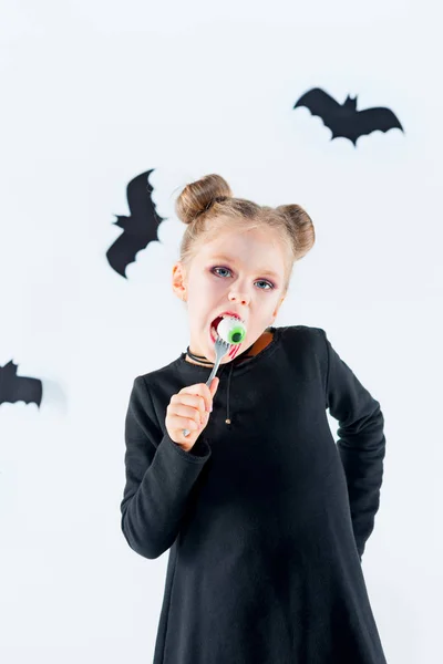 Niña bruja en vestido negro sobre accesorios mágicos. Halloween, la noche del estudio . — Foto de Stock