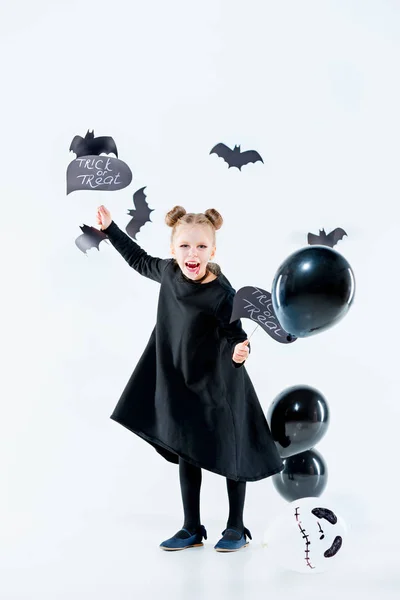 Niña bruja en vestido negro sobre accesorios mágicos. Halloween, la noche del estudio . — Foto de Stock