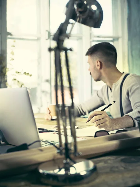 Ofisteki çizim masasında çalışan mimar