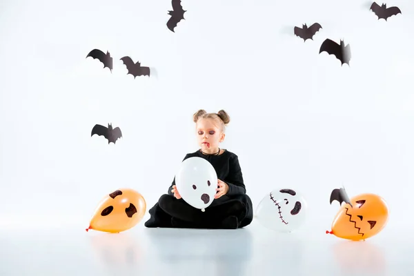 Niña bruja en vestido negro sobre accesorios mágicos. Halloween, la noche del estudio . — Foto de Stock