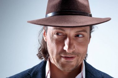 Genç portre studio gri arka plan üzerinde şapkalı adam.