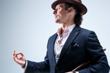 Genç portre studio gri arka plan üzerinde şapkalı adam.