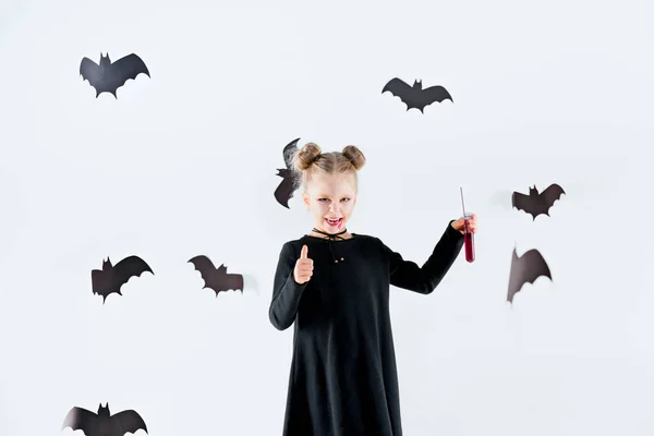 Niña bruja en vestido negro sobre accesorios mágicos. Halloween, la noche del estudio . — Foto de Stock