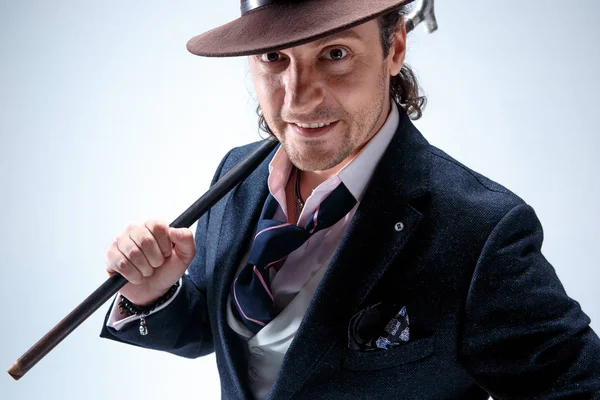 Genç portre studio gri arka plan üzerinde şapkalı adam.