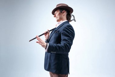 Baston tutan bir takim elbisesi ve olgun adam.