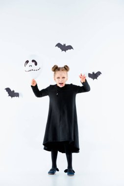 Büyülü aksesuarları üzerinde siyah elbiseli küçük kız cadı. Cadılar Bayramı, stüdyo akşam.