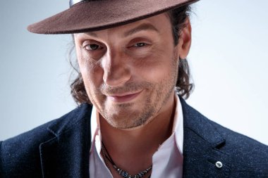 Genç portre studio gri arka plan üzerinde şapkalı adam.