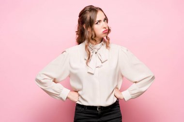 Pembe bir arka plan üzerinde ciddi hayal kırıklığına uğramış genç güzel iş kadını