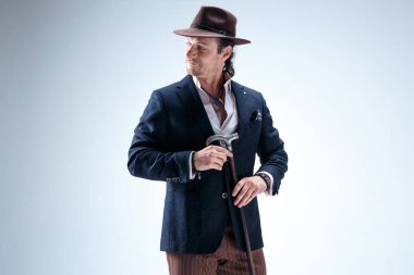 Baston tutan bir takim elbisesi ve olgun adam.