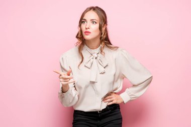 Pembe bir arka plan üzerinde ciddi hayal kırıklığına uğramış genç güzel iş kadını