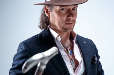 Genç portre studio gri arka plan üzerinde şapkalı adam.