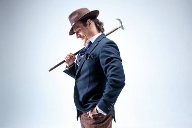 Genç portre studio gri arka plan üzerinde şapkalı adam.