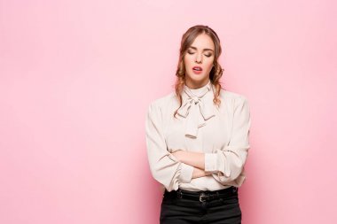 Pembe bir arka plan üzerinde ciddi hayal kırıklığına uğramış genç güzel iş kadını