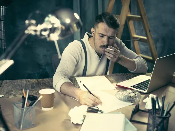 Retrato de un hombre de negocios barbudo que está revisando los detalles de su próxima reunión en su cuaderno y escribiendo . — Foto de Stock