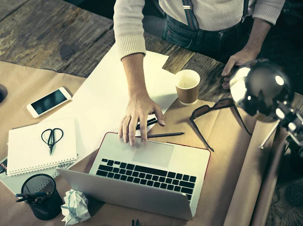 Vintage hipster de madeira vista superior do desktop, mãos masculinas usando um laptop e segurando um lápis — Fotografia de Stock