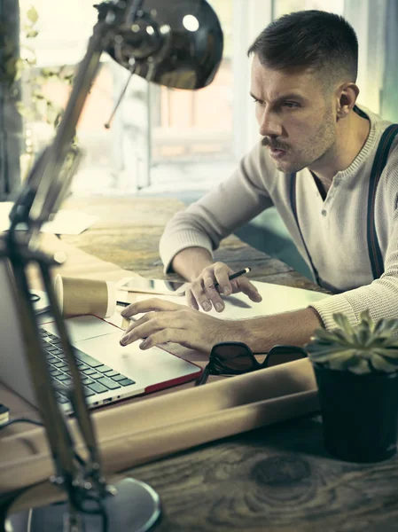 Retrato de un hombre de negocios barbudo que está revisando los detalles de su próxima reunión en su cuaderno y escribiendo . — Foto de Stock