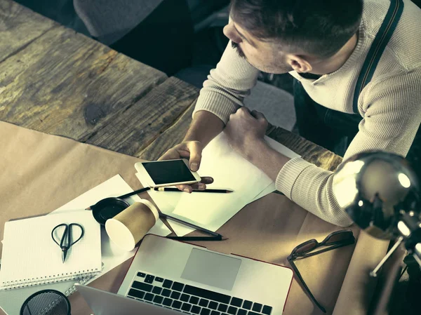 Çatı stüdyo onun defter ile çalışan sakallı bir işadamı portresi.