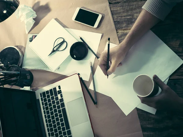 Vintage hipster ahşap masaüstü yan görünüm, erkek Kupası ve bir kalem tutan eller