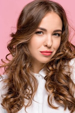 Pembe bir arka plan üzerinde ciddi hayal kırıklığına uğramış genç güzel iş kadını