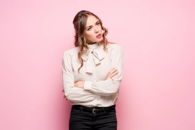 Pembe bir arka plan üzerinde ciddi hayal kırıklığına uğramış genç güzel iş kadını