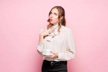 Pembe bir arka plan üzerinde ciddi hayal kırıklığına uğramış genç güzel iş kadını