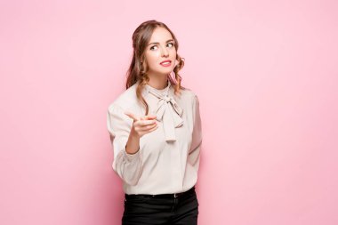 Pembe bir arka plan üzerinde ciddi hayal kırıklığına uğramış genç güzel iş kadını