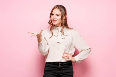 Pembe bir arka plan üzerinde ciddi hayal kırıklığına uğramış genç güzel iş kadını