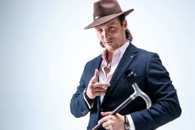 Genç portre studio gri arka plan üzerinde şapkalı adam.