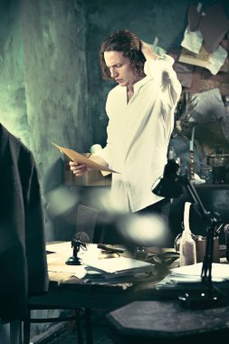 Yazar iş başında. Masanın ayakta ve zihninde bir şey yapma yakışıklı genç yazar