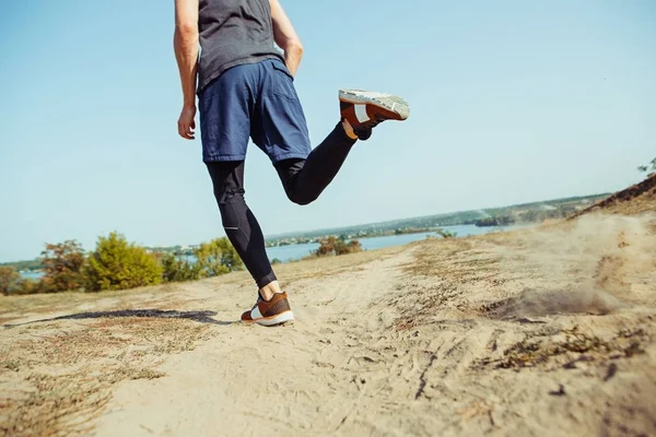 Running sport. Man runner sprinting outdoor in scenic nature. Fit muscular male athlete training trail running for marathon run.