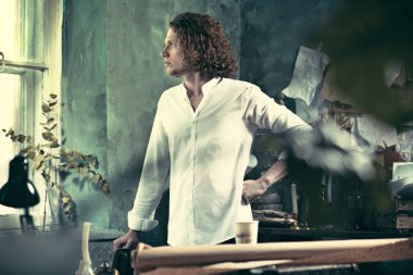 Yazar iş başında. Masanın ayakta ve zihninde bir şey yapma yakışıklı genç yazar