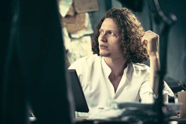 Yazar iş başında. Masada oturan ve bir şey onun eskiz defteri evde yazma yakışıklı genç yazar