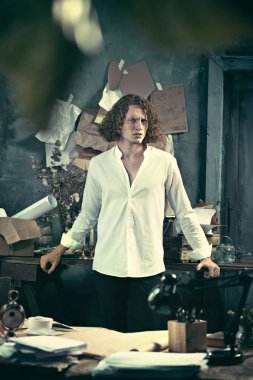 Yazar iş başında. Masanın ayakta ve zihninde bir şey yapma yakışıklı genç yazar