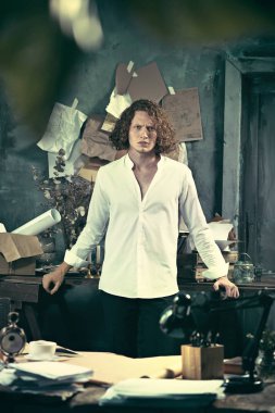Yazar iş başında. Masanın ayakta ve zihninde evde bir şeyler yapma yakışıklı genç yazar