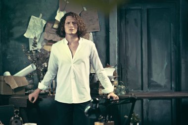 Yazar iş başında. Masanın ayakta ve zihninde bir şey yapma yakışıklı genç yazar