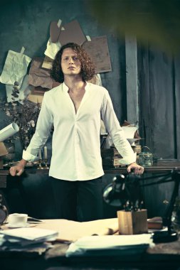 Yazar iş başında. Masanın ayakta ve zihninde evde bir şeyler yapma yakışıklı genç yazar