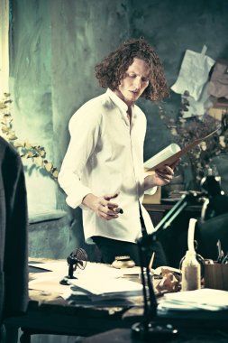 Yazar iş başında. Masanın ayakta ve zihninde bir şey yapma yakışıklı genç yazar