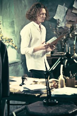 Yazar iş başında. Masanın ayakta ve zihninde bir şey yapma yakışıklı genç yazar