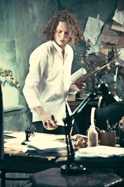 Yazar iş başında. Masanın ayakta ve zihninde bir şey yapma yakışıklı genç yazar