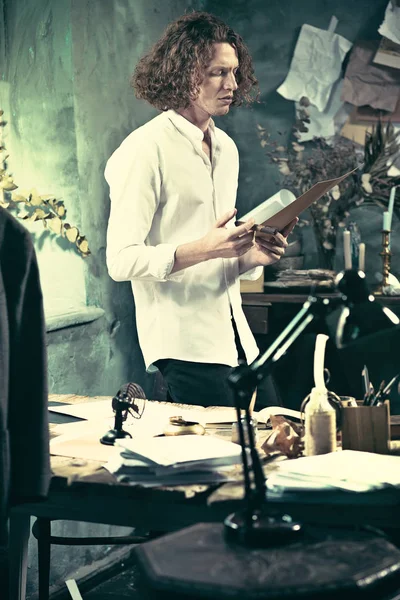 Yazar iş başında. Masanın ayakta ve zihninde bir şey yapma yakışıklı genç yazar