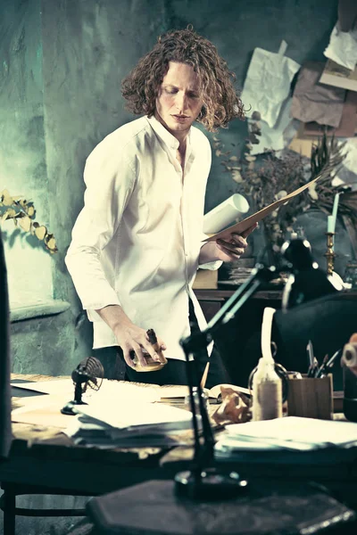 Yazar iş başında. Masanın ayakta ve zihninde bir şey yapma yakışıklı genç yazar