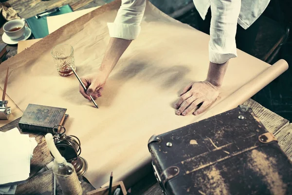 Arquitecto trabajando en mesa de dibujo en la oficina —  Fotos de Stock